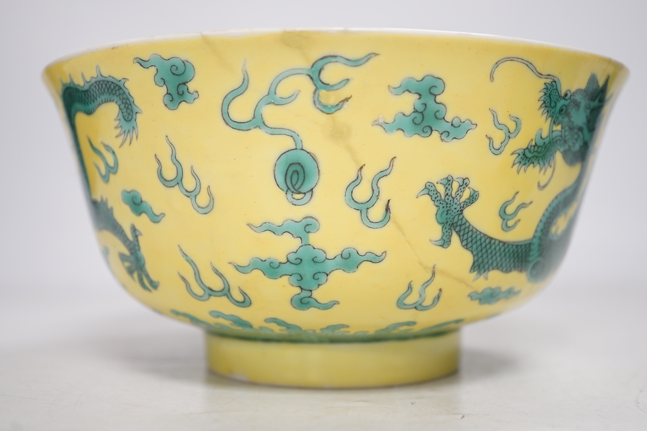 A Chinese yellow ground 'dragon' bowl, probably late Qing dynasty, and a similar floral cup, bowl 9cm high, 18.5cm diameter. Condition - bowl has a large section restored